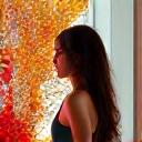 現代的なフローラルアート作品の横に立つ、創造的なエネルギーに満ちた若手フローラルアーティスト