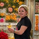 活気ある花屋の店内で笑顔で顧客と話すフローラルビジネスの専門家