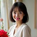 完成した伝統的な生け花の隣で誇らしげに微笑む、30代の日本人女性、ハルカ。
