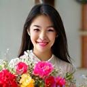 笑顔で花束を抱え、自宅の作業室でクリエイティブな仕事をしている20代の日本人女性、ナオミ。